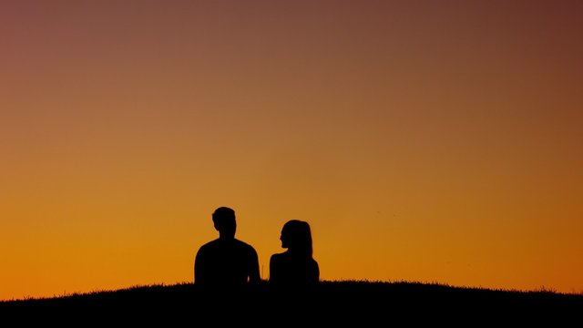 In love couple walking on sunset background.