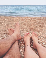 Couple lying on beach watching the ocean in front of them. 