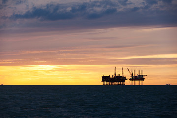 Silhouette of oil platform at sunset