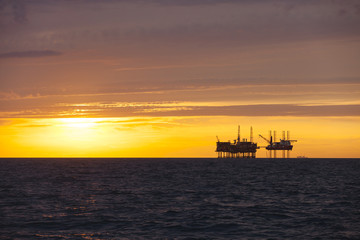 Fototapeta premium Silhouette of oil platform at sunset