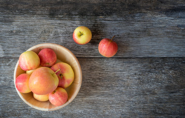 Apples in a wood bowl on wooden background.