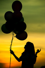 Silhouette of girl with balloon.