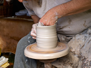 Hands working on pottery wheel