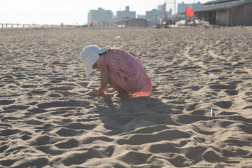 Little girl playing with sand on the beach