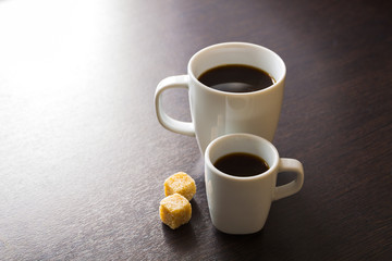 Cup of espresso and mug of long coffee with sugar