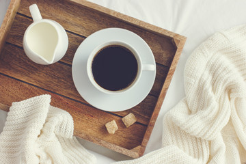 cup of coffee, cream and brown sugar on wooden tray