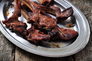 roasted rack of lamb with rosemary and garlic on an iron plate