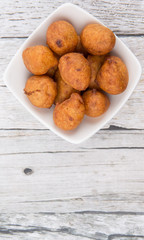 Popular Malaysian fritter snack deep fried banana balls or locally known as Cekodok Pisang in white bowl