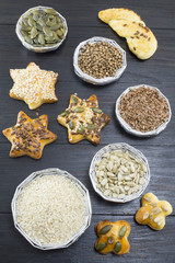 Various seeds in shiny bowls with homemade pastry with seeds