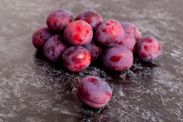 Fresh Dark Plums on black Table