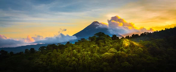 Wall murals Jungle Arenal Volcano at Sunrise...A rare sight at the perfect 15 second window to capture sunrise in all of it's glory.  Light glistens off the clouds and the mountain and the jungle.