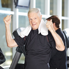 Alter Mann auf Laufband im Fitnesscenter