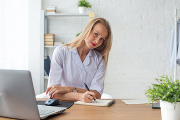 Portrait of physician working in her office writing prescription