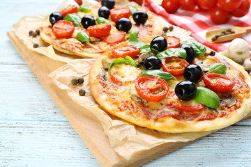 Tasty pizza with vegetables and basil on table close up