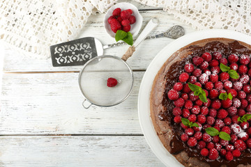 Cake with Chocolate Glaze and raspberries on color wooden background