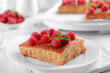 Fresh pie with raspberry in white plate on wooden table, closeup