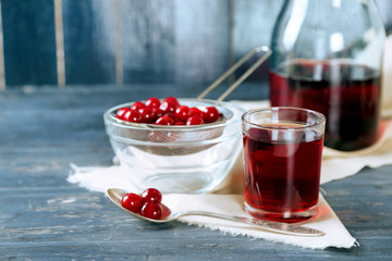 Sweet homemade cherry juice on table, on color wooden background