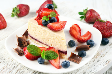 Delicious cheesecake with berries on table close up