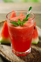 Glass of watermelon juice on wooden table, closeup