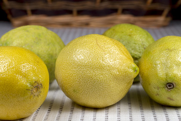 Several lemons in front of a wicker basket