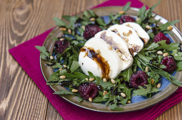 Arugula salad with mozzarella raspberries pine nuts and balsamic vinegar dressing   