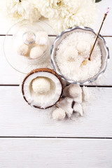 Homemade Candies in coconut flakes and fresh coconut on light background