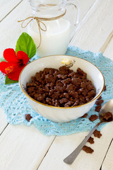 Cereal chocolate balls jug of milk on a white wooden table