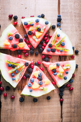 colorful tropical fruit watermelon pizza topped with kiwifruit,