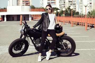 Fototapeta premium Biker girl sitting on vintage custom motorcycle