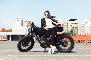 Obraz na płótnie Canvas Biker girl sitting on vintage custom motorcycle