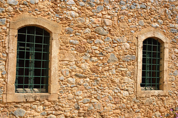 Fototapeta na wymiar The wall of an old house with two windows.