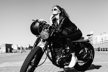Biker-Mädchen, das auf einem Vintage-Custom-Motorrad sitzt
