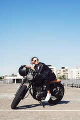 Obraz premium Biker girl sitting on vintage custom motorcycle