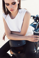Fototapeta na wymiar girl with cup of coffee sitting on vintage custom motorcycle