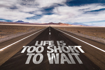 Life Is Too Short To Wait written on desert road
