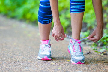 Close-up on shoe of athlete runner woman feet running on road 