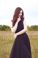 Woman with long dark hair and black feathers outdoors