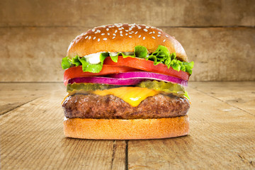Single solo burger hamburger cheeseburger on table wooden surface delicious perfect deluxe sandwich - obrazy, fototapety, plakaty