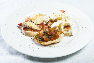 Bruschetta with prosciutto, goat cheese and fried tomatoes