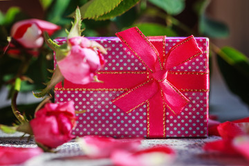 Colorful gift box (package) with  old roses background.
