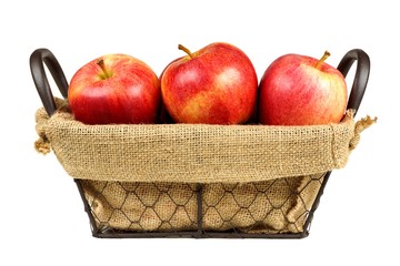 Fresh apples in a vintage wire basket with burlap isolated on a white background