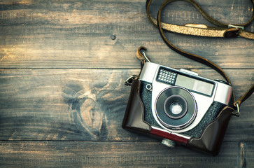 Vintage camera on rustic wooden background. Retro style