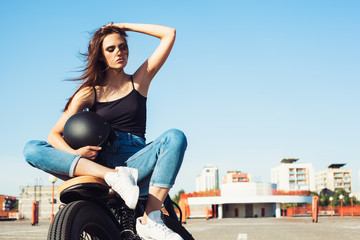 Fototapeta na wymiar Biker girl sitting on vintage custom motorcycle