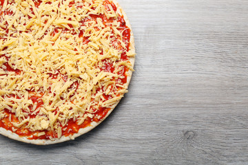 Raw pizza on wooden background