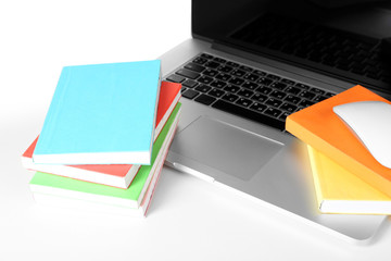 Stack of books with laptop close up