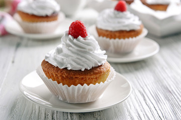 Delicious cupcakes with berries on table close up
