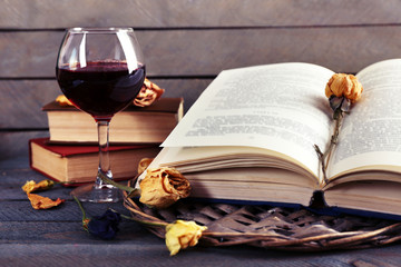 Beautiful composition with glass of wine with old books on table close up