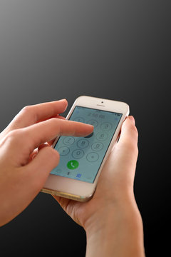 Finger touch number on smartphone to make a call on black background