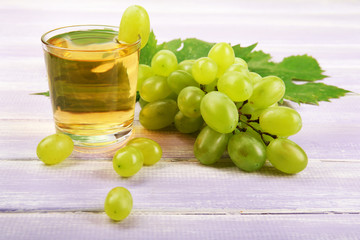 Glass of grape juice on wooden table, closeup