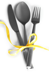 Cutlery tied with ribbon on light background